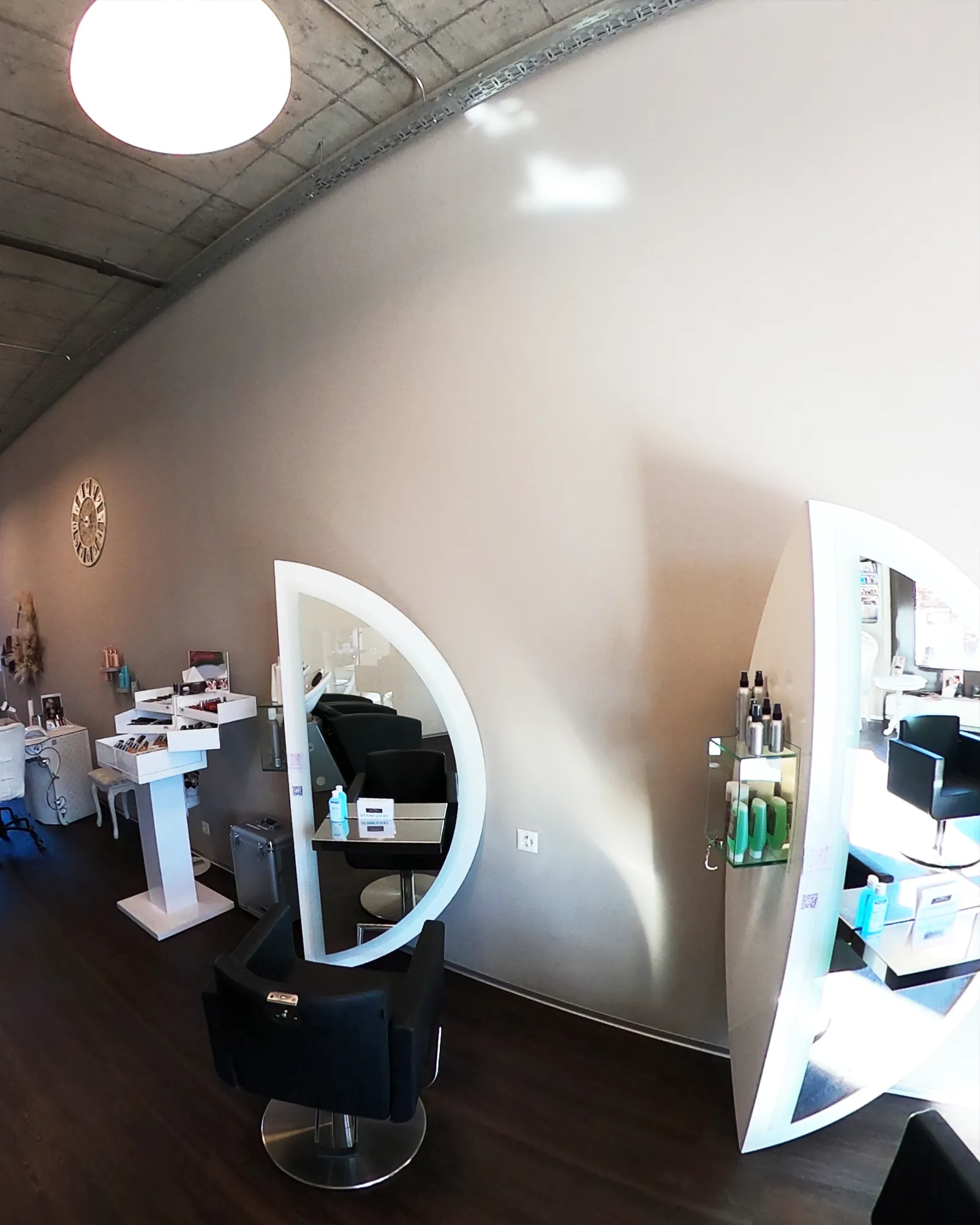 Coiffeur-Arbeitsplätze mit runden Spiegeln und warmem Licht im House of Beauty Winterthur